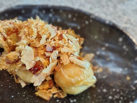 Delicious Takoyaki Balls Topped with katsuobushi and Sauce.