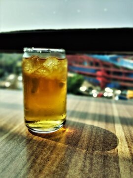 Refreshing Iced Tea in a Glass with Ice Cubes on a Wooden Table.