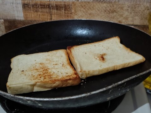 Two Slices of Bread Toasting in a Frying Pan.