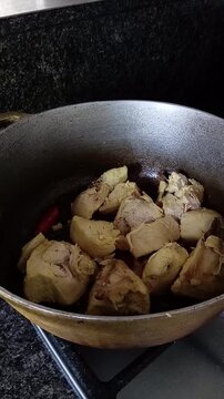 Una toma de cerca de un sart&eacute;n en donde se encuentra trozos de pollos ricos  cocinando con aceite y saliendo vapor. Estilo de vida 