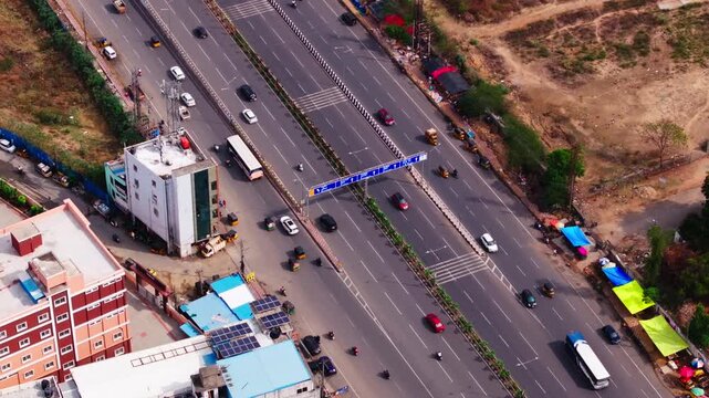Traffic flow on national highway 65 with bhel flyover, sign board and rumble strips at chanda nagar, hyderabad, telangana, india. day time, zoom in shot, drone shot, 4k.