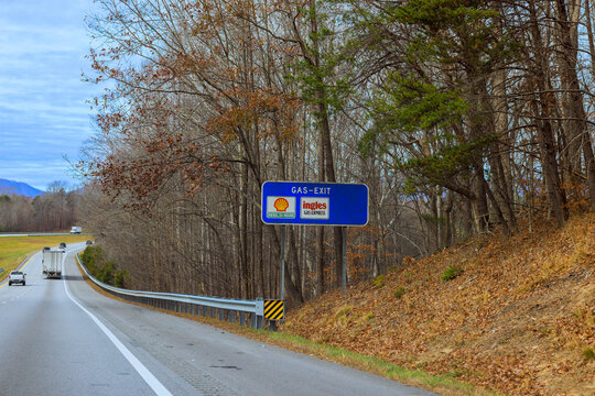 02 December 2025 Asheville, North Carolina Road sign indicates gas exit on highway Shell station, Ingles grocery store are nearby.
