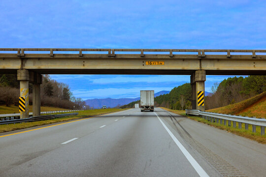 Truck drives on highway under large bridge with hills on North Carolina
