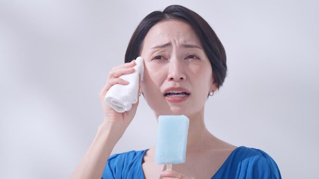 夏にアイスを食べて頭が痛い女性（暑い・熱中症）