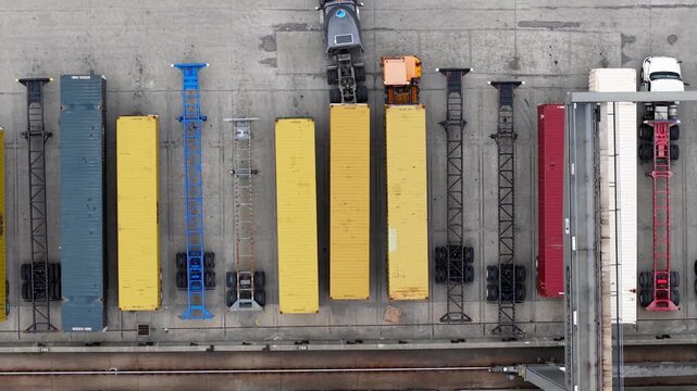 Top down aerial view of trucks moving cargo containers