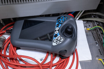 Disconnected touch controller with a red cable lying inside an electrical cabinet. © lapis2380