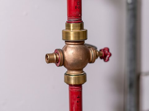 Backflow preventer assembly installed on water line above commercial mop sink in utility area