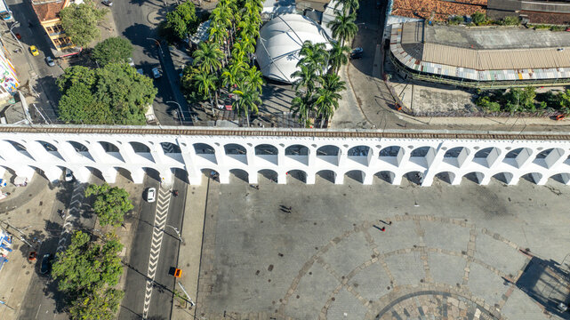 Arcos da Lapa featuring its iconic white arches stretching across the urban landscape with surrounding buildings and clear sky in Rio de Janeiro, Rio de Janeiro, Brazil. Aerial view.