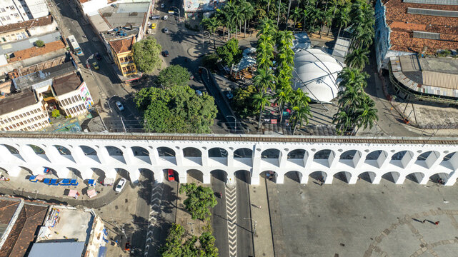 Arcos da Lapa featuring its iconic white arches stretching across the urban landscape with surrounding buildings and clear sky in Rio de Janeiro, Rio de Janeiro, Brazil. Aerial view.