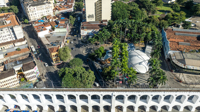 Arcos da Lapa featuring its iconic white arches stretching across the urban landscape with surrounding buildings and clear sky in Rio de Janeiro, Rio de Janeiro, Brazil. Aerial view.