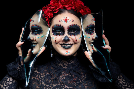 Halloween beauty portrait of smiling woman with Santa Muerte makeup. Female with a shards of mirror.