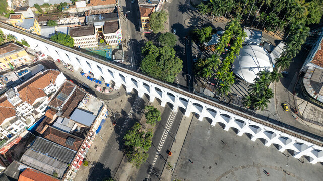 Arcos da Lapa featuring its iconic white arches stretching across the urban landscape with surrounding buildings and clear sky in Rio de Janeiro, Rio de Janeiro, Brazil. Aerial view.