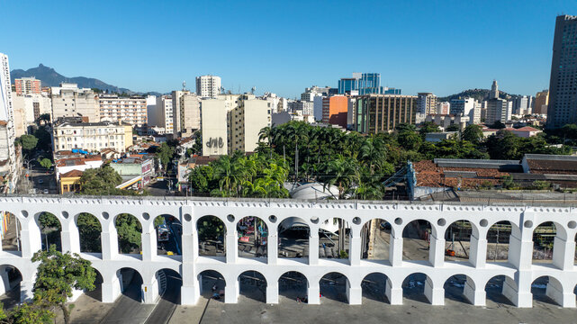 Arcos da Lapa featuring its iconic white arches stretching across the urban landscape with surrounding buildings and clear sky in Rio de Janeiro, Rio de Janeiro, Brazil. Aerial view.
