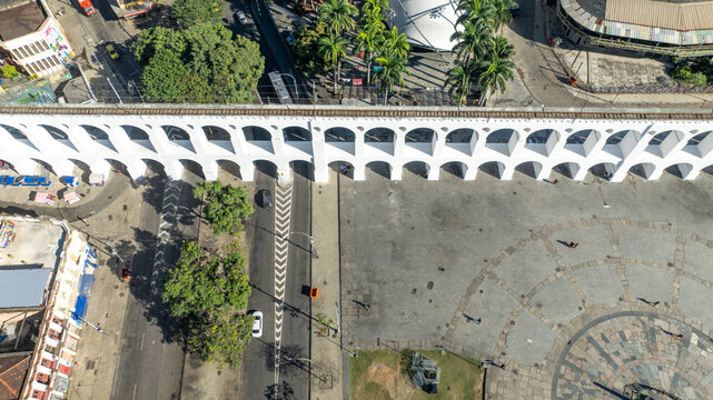 Arcos da Lapa featuring its iconic white arches stretching across the urban landscape with surrounding buildings and clear sky in Rio de Janeiro, Rio de Janeiro, Brazil. Aerial view.