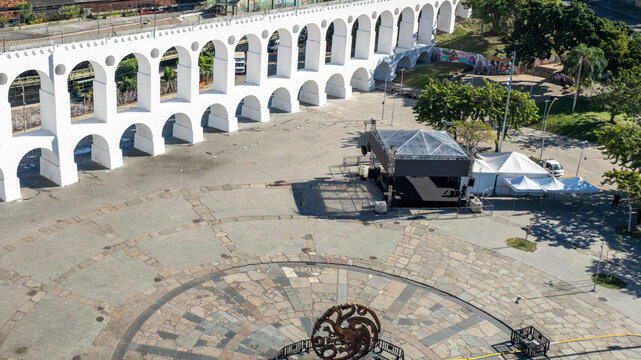 Arcos da Lapa featuring its iconic white arches stretching across the urban landscape with surrounding buildings and clear sky in Rio de Janeiro, Rio de Janeiro, Brazil. Aerial view.
