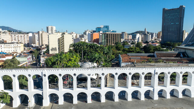 Arcos da Lapa featuring its iconic white arches stretching across the urban landscape with surrounding buildings and clear sky in Rio de Janeiro, Rio de Janeiro, Brazil. Aerial view.