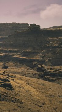Stunning rugged cliffs rise dramatically from the earth, bathed in warm evening light. Shadows dance across the rocky terrain, creating an enchanting scene.