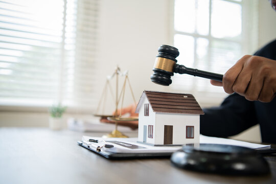 Lawyer reviewing real estate contracts, advising client on property purchase, mortgage, legal approval, financial planning, ownership, and successful closing transaction.