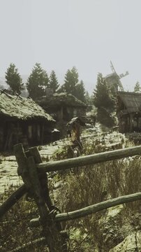 A peaceful village displays quaint wooden houses under a warm glow. Tall green trees frame the scene, while a nearby windmill gently turns in the breeze. Nature thrives in this calm setting.