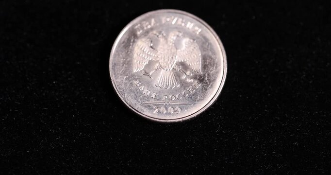 Russian coin  two rubles on a black surface, official money worth 2 rubles of the Russian Federation lies on a black surface, real currency
