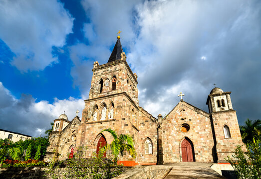 Facade of the historic stone Cathedral of Our Lady of Fair Haven under a blue sky in Roseau, Dominica