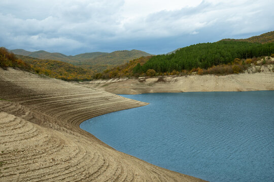 Tranquil lake reflects rolling hills and colorful autumn trees