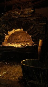 Flames flicker in a charming stone fireplace, casting a warm light in a rustic cabin. The scene evokes comfort, inviting moments of relaxation and good company during the night.