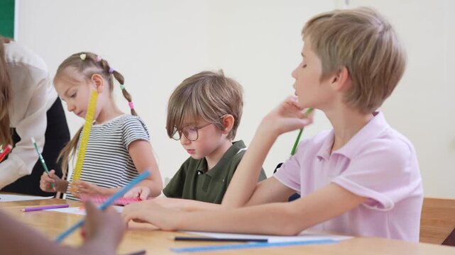 Concentrated students writing at their desks in modern school, Diverse group of elementary students studying in classroom, Children learning together in primary school classroom