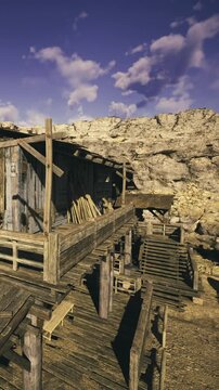 Rustic wooden buildings stand sturdy against a rugged terrain filled with golden rocks and blue skies. This place tells stories of time, nature, and human endeavor in harmony.
