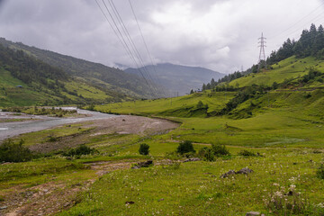 Power transmission line crossing a green valley in Mehele, Nepal © ThamiShankar