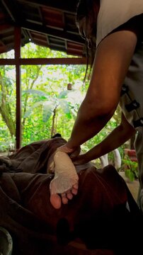 Masseuse applying a clay mask during a foot spa treatment
