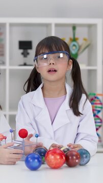 Elementary Student in Lab Coat Explaining Solar System Science Project
