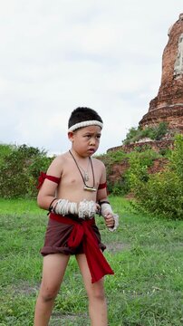 Young Boy Practicing Muay Thai Martial Arts at Ancient Temple Ruins
