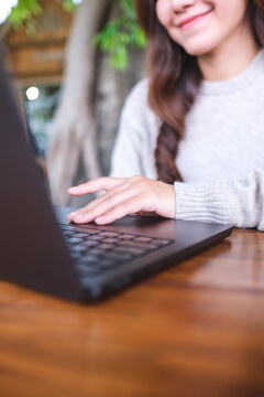 Vertical closeup image of a woman working on laptop computer