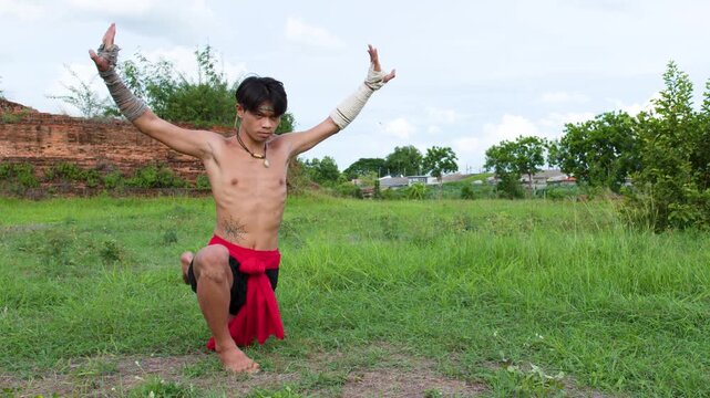 Traditional Muay Boran Martial Artist Performing Ritual Pose Outdoors