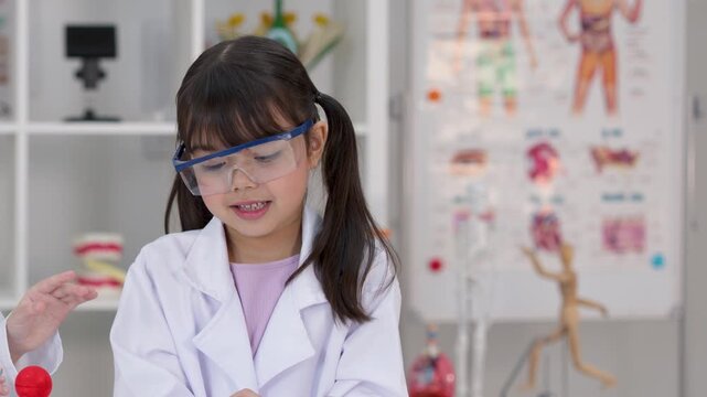Elementary Student in Lab Coat Presenting Science Project in Classroom
