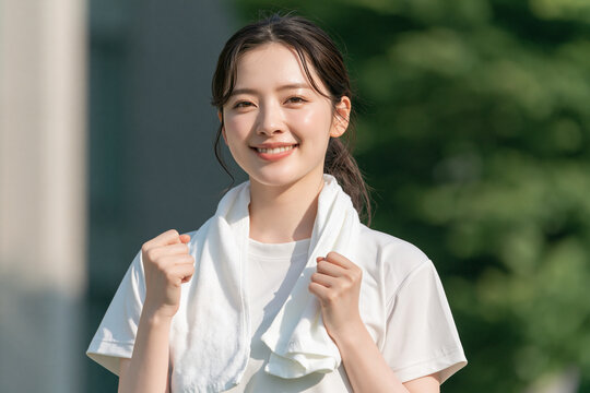 タオルを首にかけた笑顔の日本人女性のフィットネスイメージ