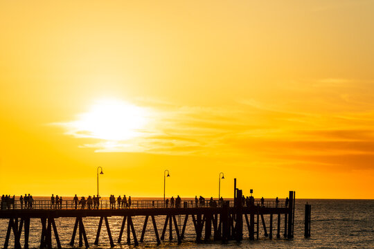People strolling along Glenelg Jetty during summer sunset, Adelaide, SA