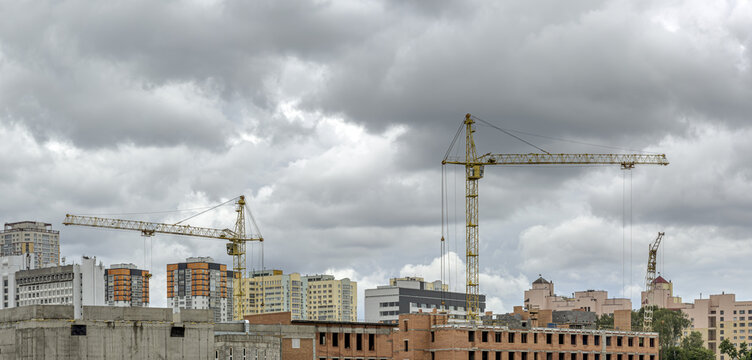 modern buildings under construction. cranes on the construction site against overcast sky.