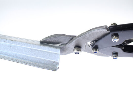 metal shears cut a galvanized sheet metal  profile in a close up industrial composition, sharp blades slicing through steel, metal shavings falling, cutting metal isolated on pure white background