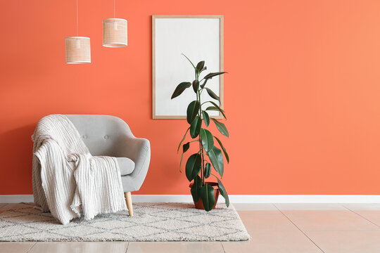 Interior of stylish living room with grey armchair, plant and lamps
