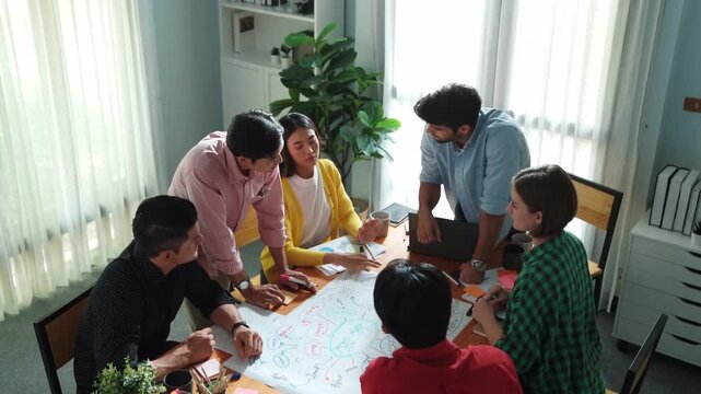 Top view of happy creative team putting hands together while drawing mind map. Group of diverse people working together brainstorming marketing idea and sharing plan by using sticky notes. Convocation