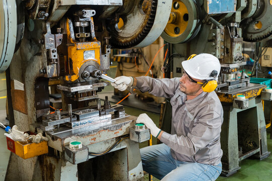 Engineer tightening bolt with wrench on mechanical power press die close view