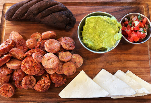 Entrada de embutidos, acompa&ntilde;ados de frijoles negros, queso y guacamol. Toma superior.