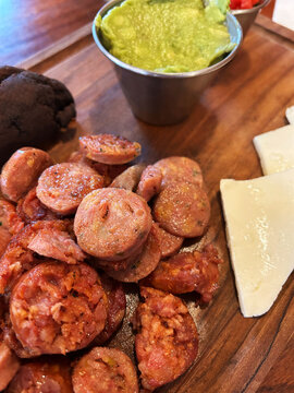 Entrada de embutidos, acompa&ntilde;ados de frijoles negros, queso y guacamol. Toma Vertical.