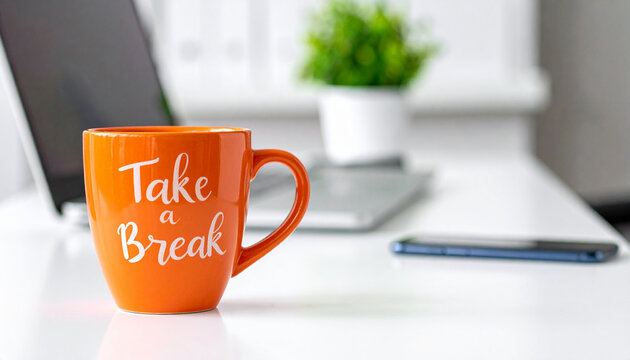 Orange coffee mug with Take a Break text on office desk