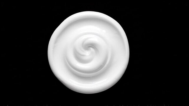 White cream spiral texture swirling against a black background