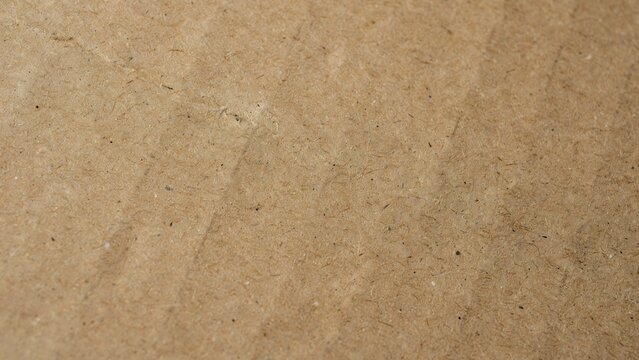 Natural brown recycled paper texture with rough fibers and organic speckles for design use