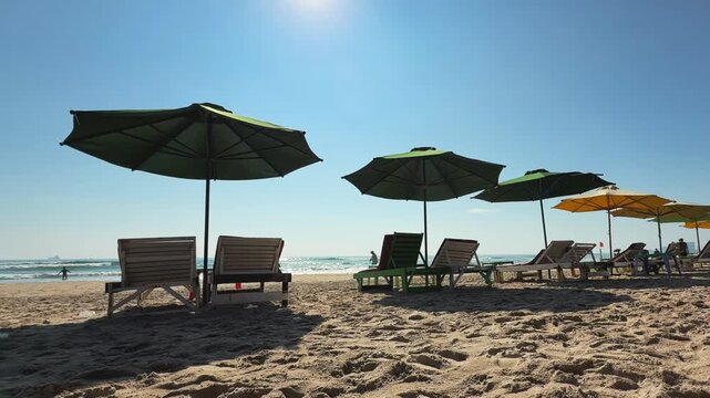 Green Beach Umbrellas Row with People Walking Tropical Beach Day Scene