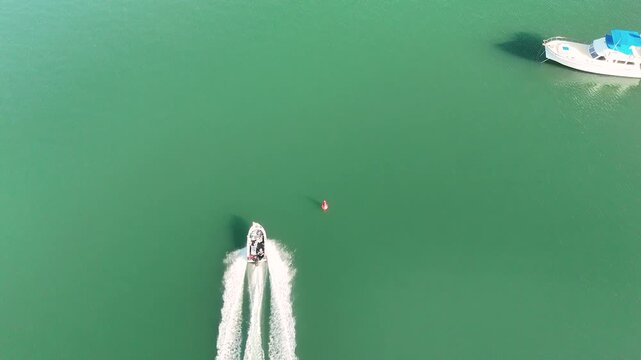 Aerial Top Down View of Speedboat Cruising Through Turquoise Water